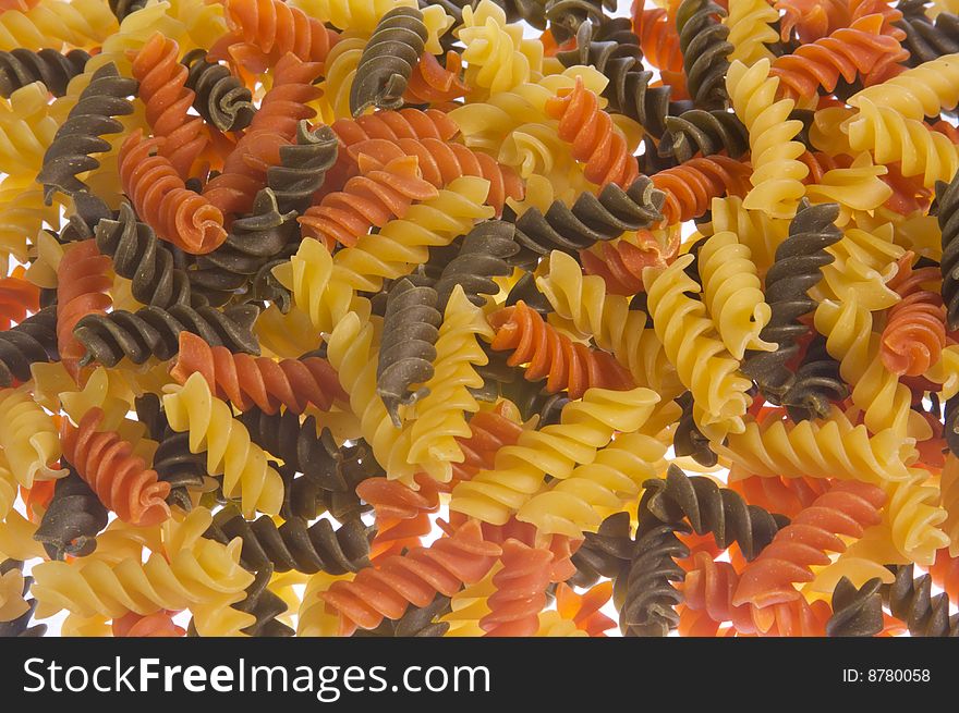 Tri-color rotini pasta over a white background