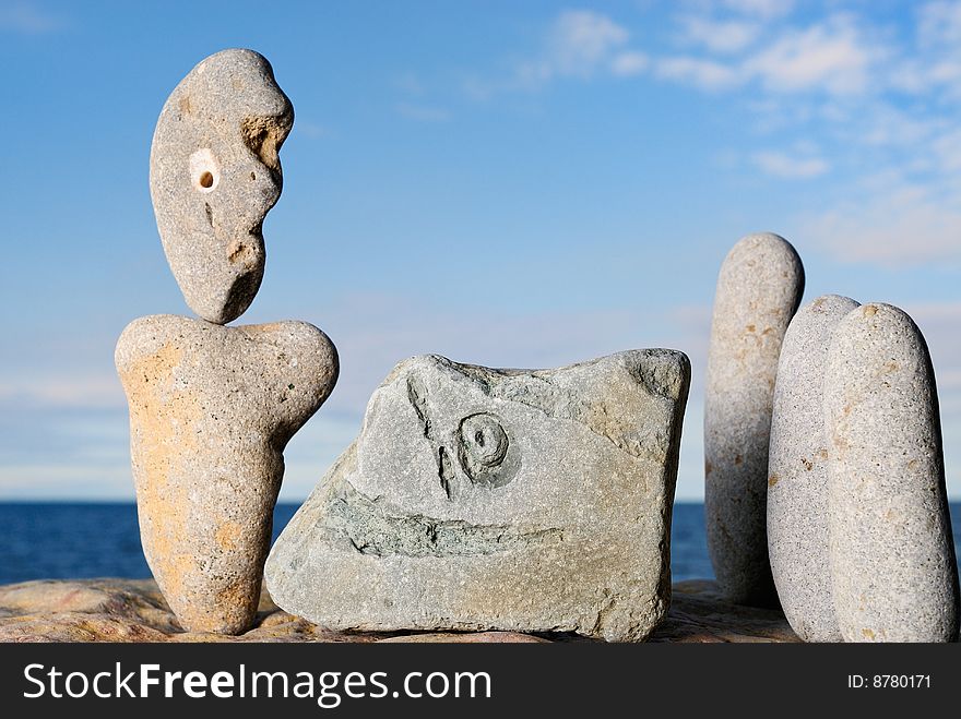 Sculptural group of stone idols on the shore of ocean