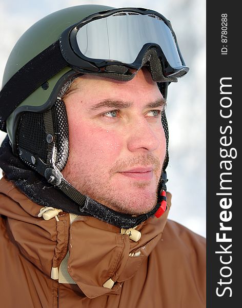 Portrait of a good looking, middle aged snowboarder with protection helmet and snow goggles. Portrait of a good looking, middle aged snowboarder with protection helmet and snow goggles.