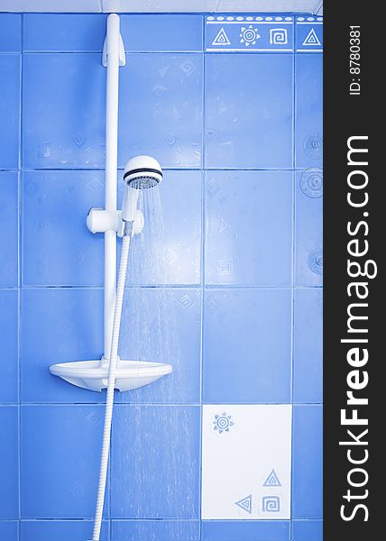 White shower and drops of water on blue tiling background. White shower and drops of water on blue tiling background
