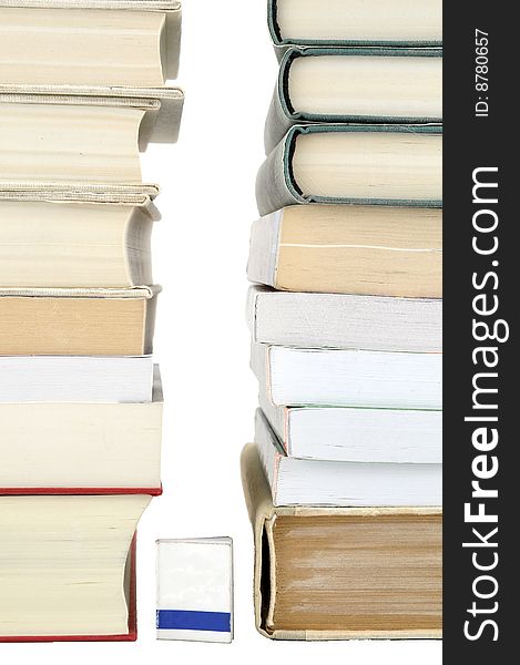 Small book between two stacks of books on white background