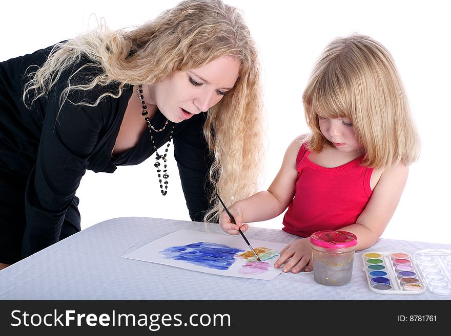 Mom and daughter with paint beside table isolated on white