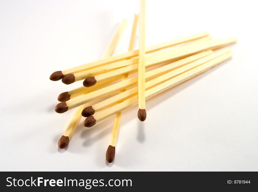 Pile of matches with brown tips on a white background