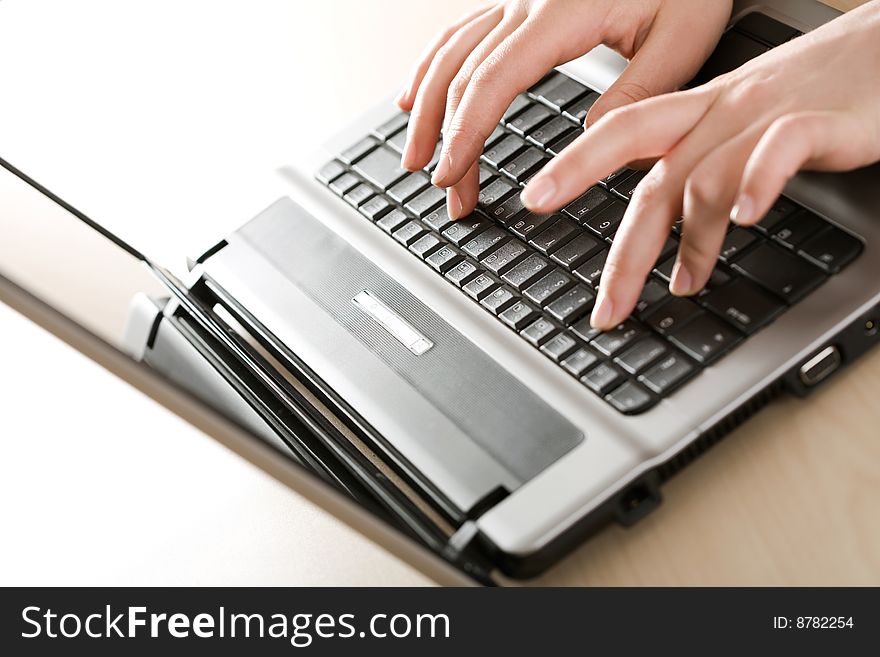 Close-up of female fingers typing a business document on the laptop. Close-up of female fingers typing a business document on the laptop