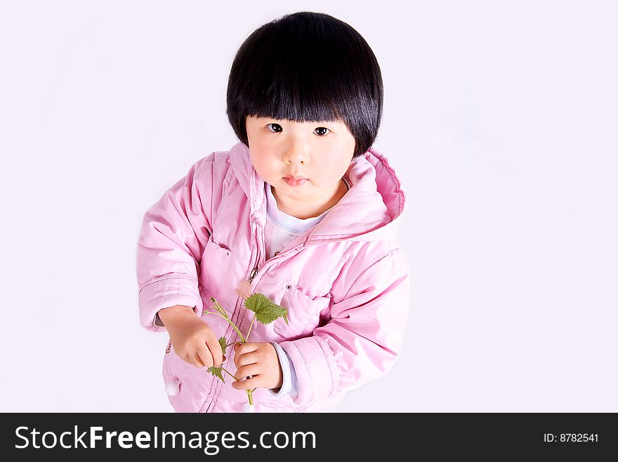 A picture of a little chinese girl standing with tender leaves in hand and looking upward. A picture of a little chinese girl standing with tender leaves in hand and looking upward