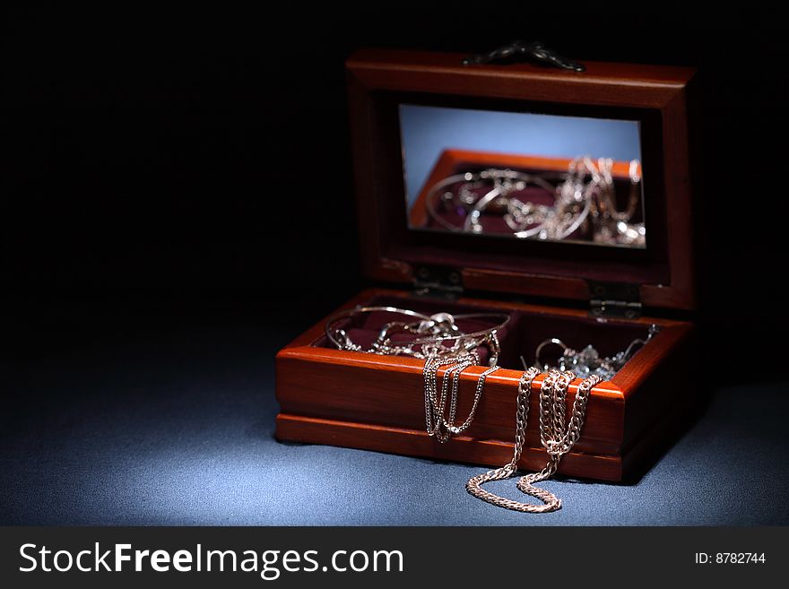Nice wooden casket with jewelry on dark background. Nice wooden casket with jewelry on dark background