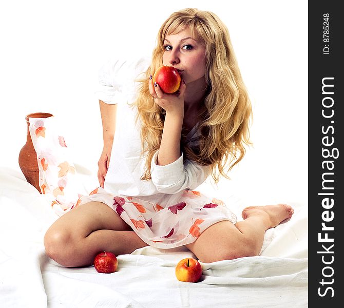 Portrait of a young blonde girl with apples in the white background