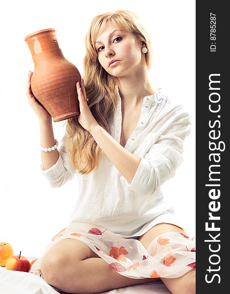 Portrait of a young blonde girl with jug in the white background