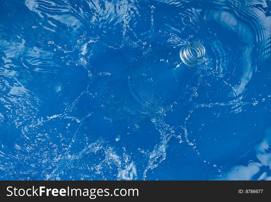 Bottle with splashing water.Blue Background