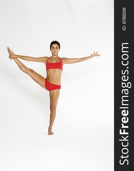 Studio shot of a young woman in yoga position