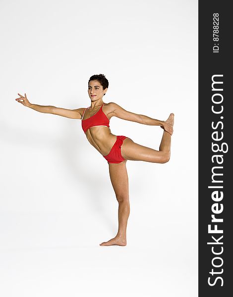 Studio shot of a young woman in yoga position