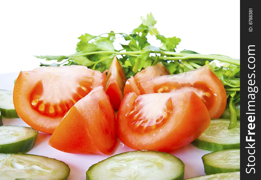 Tomatoes and cucumber on the plate with white background. Tomatoes and cucumber on the plate with white background
