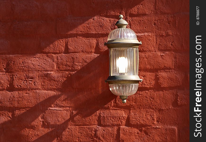 Color photo of red brick wall with an electric lamp