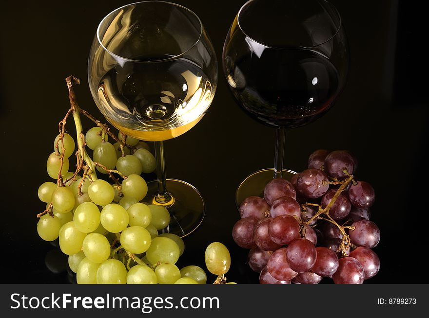 Two glasses of wine with grapes. Two glasses of wine with grapes