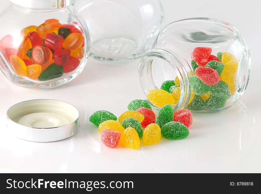Fruit jellys in glass phial on white background