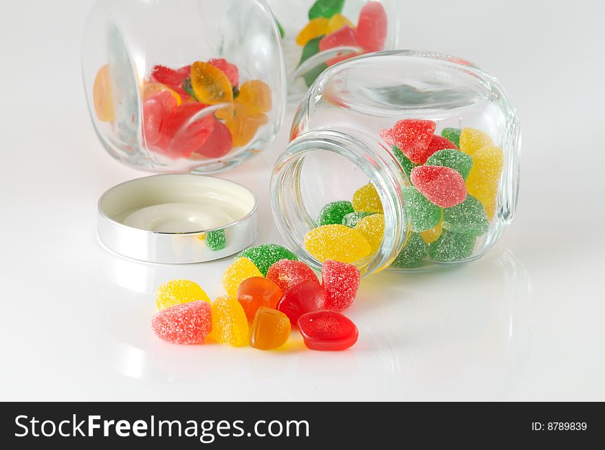 Fruit jellys in glass phial on white background