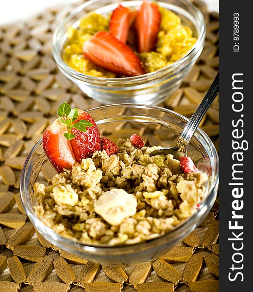 Cornflakes and musli with strawberry on a wooden cover