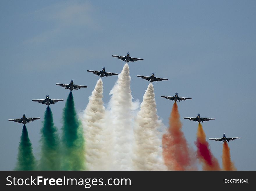 Frecce Tricolori flying in V formation and leaving Italian flag colored smoke trails.