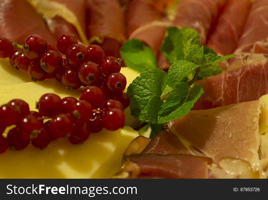 Plate of cold cuts and cheese decorated with mint and cranberries. Plate of cold cuts and cheese decorated with mint and cranberries.