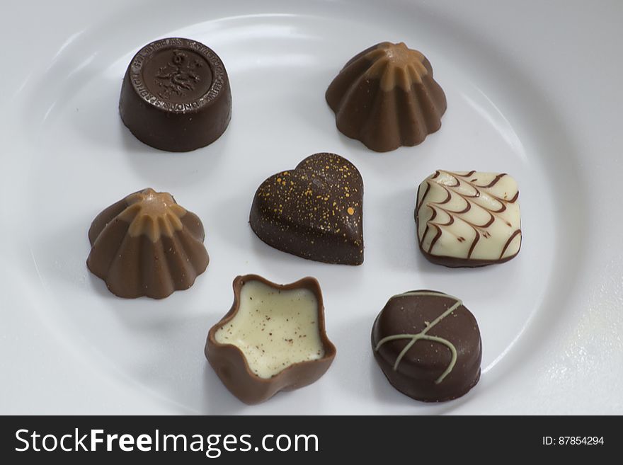 Picture of assorted swiss chocolate bonbons isolated on white plate.