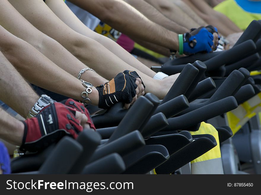 People Lined Up On Exercise Bikes At A Fitness Session.