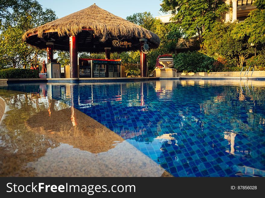 Scenic view of luxurious hotel outdoors swimming pool with beach bar in background. Scenic view of luxurious hotel outdoors swimming pool with beach bar in background.