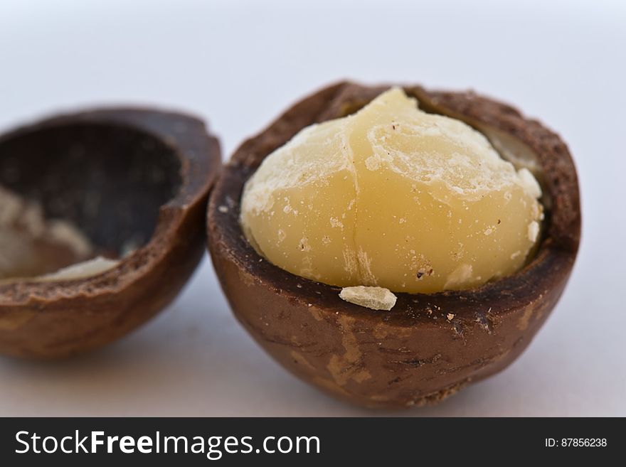 Macadamia nut cracked open exposing the white kernel. Besides nutritional value they are also used for cosmetic oils. Macadamia nut cracked open exposing the white kernel. Besides nutritional value they are also used for cosmetic oils.