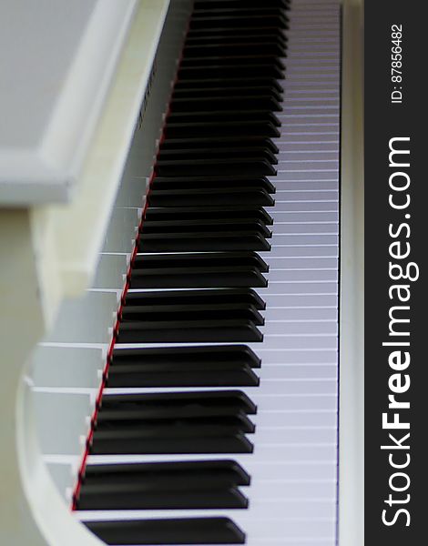 Ivory colored piano with open lid exposing keys. Ivory colored piano with open lid exposing keys