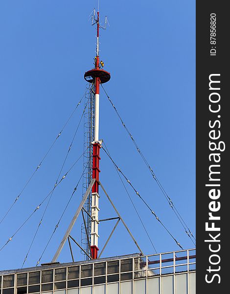 Transmitting antenna on top of a building secured by guy wires. Transmitting antenna on top of a building secured by guy wires.