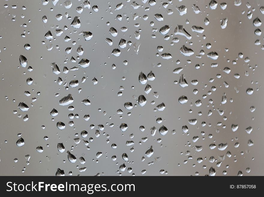 Rain droplets on a window pane in winter time. Rain droplets on a window pane in winter time.