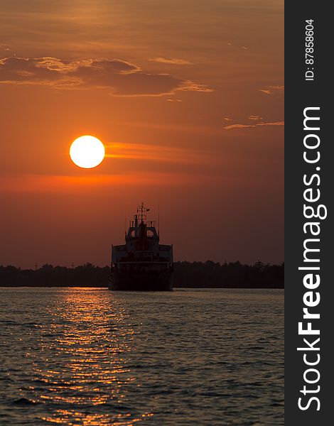 Large transport vessel sailing under sunset light on Danube. Large transport vessel sailing under sunset light on Danube