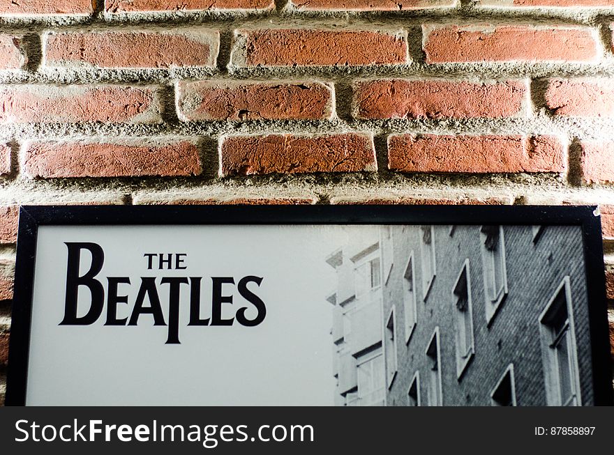 A brick wall with a poster of the band The Beatles. A brick wall with a poster of the band The Beatles.