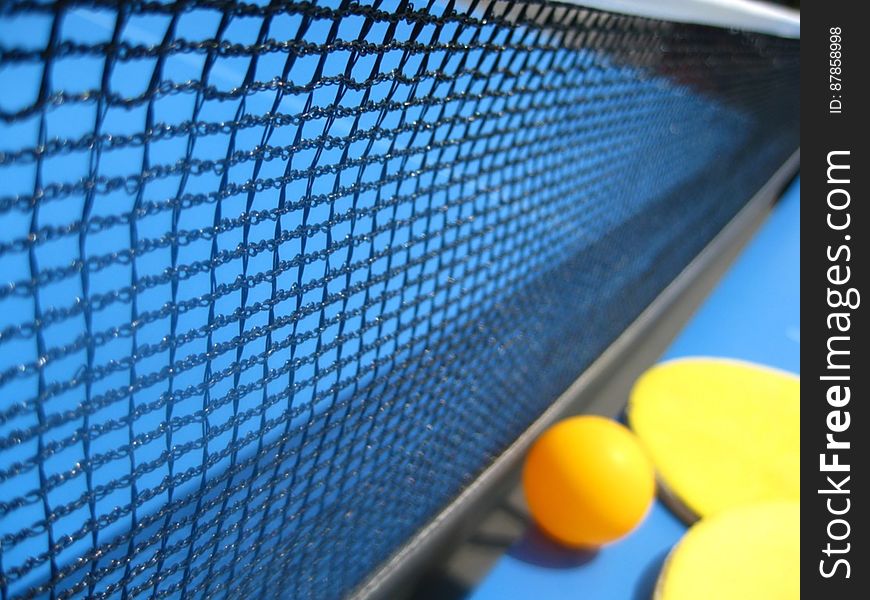 table-tennis-ball-and-racket-against-net