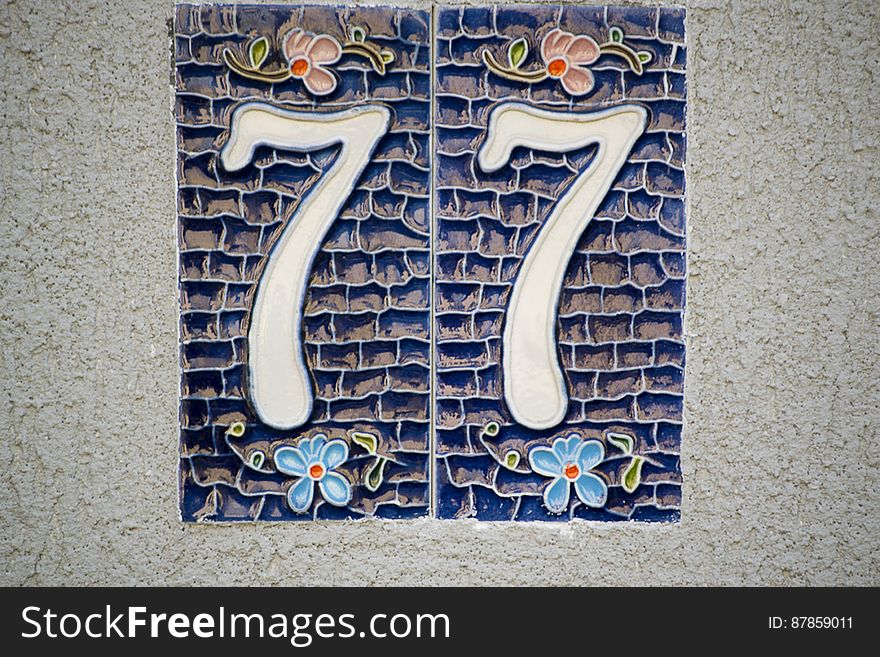 Picture of a ceramic house numbering plate with floral motifs.