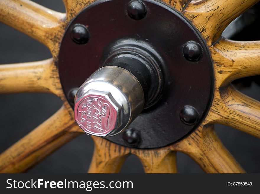 Picture of cap and bolts on wheel of a Ford Model T. Wooden spokes were used, soon to be replaced by steel ones.