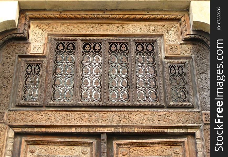 wrought-iron-ornamentation-above-carved-wooden-door