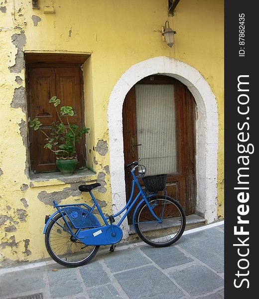 blue-bicycle-leaning-on-wall