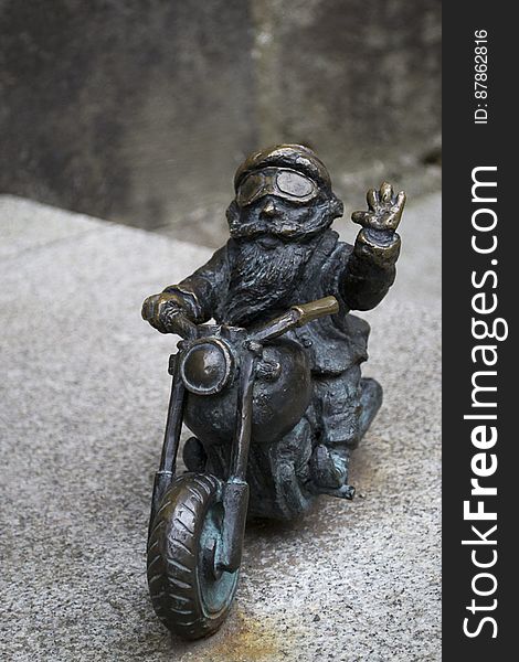 Dwarf riding motorcycle and waving at the camera. Dwarf riding motorcycle and waving at the camera.