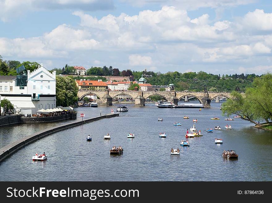 Numerous people in cycle boats invade Vltava river during summer to cool off and admire architecture on banks. Numerous people in cycle boats invade Vltava river during summer to cool off and admire architecture on banks.