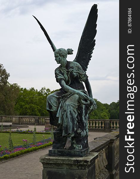Sculpture of a winged angel holding a wreath in front of Orangerie in Potsdam. Visitors like to rub the statue&#039;s bare left foot. Sculpture of a winged angel holding a wreath in front of Orangerie in Potsdam. Visitors like to rub the statue&#039;s bare left foot.