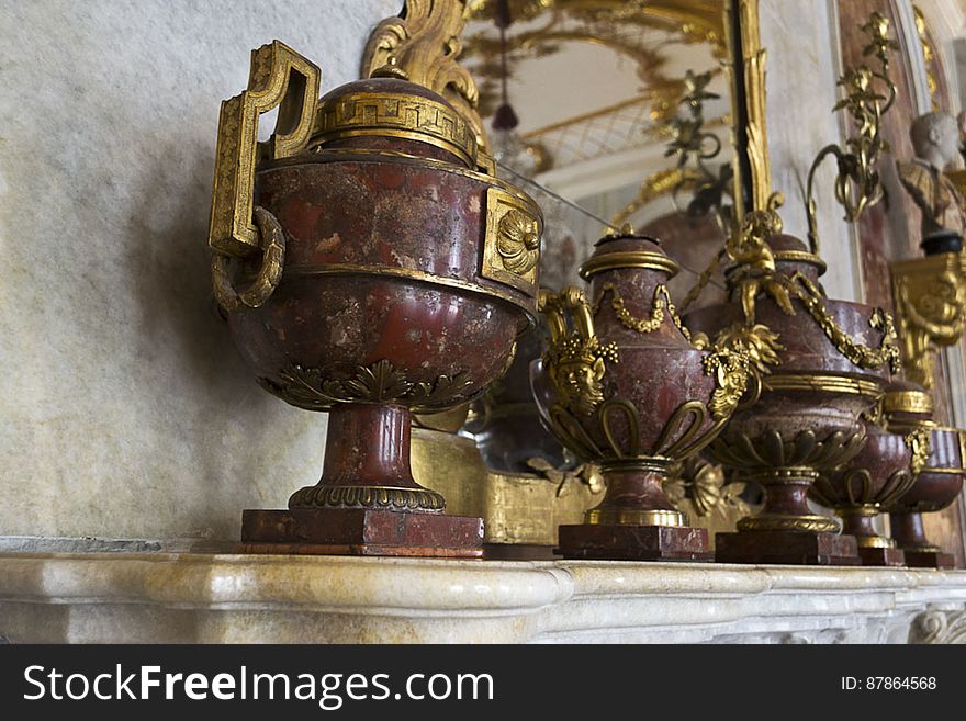 Red marble vases with gilt-bronze handles and decorations.