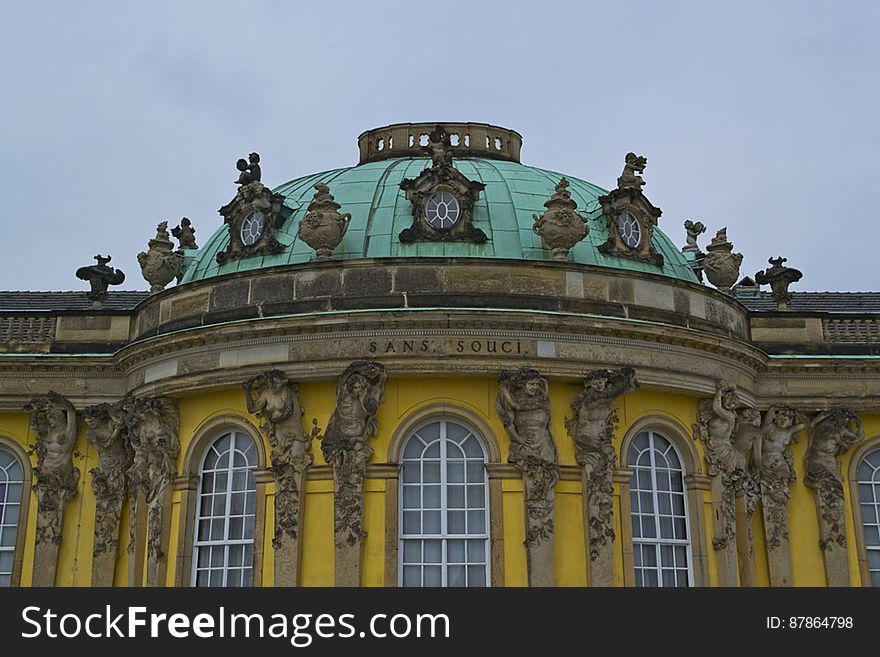 Sanssouci Rococo front with dome sustained by Atlas and Caryatids pairs, cherubs on roof and the name of the palace in gilded letters. Sanssouci Rococo front with dome sustained by Atlas and Caryatids pairs, cherubs on roof and the name of the palace in gilded letters.