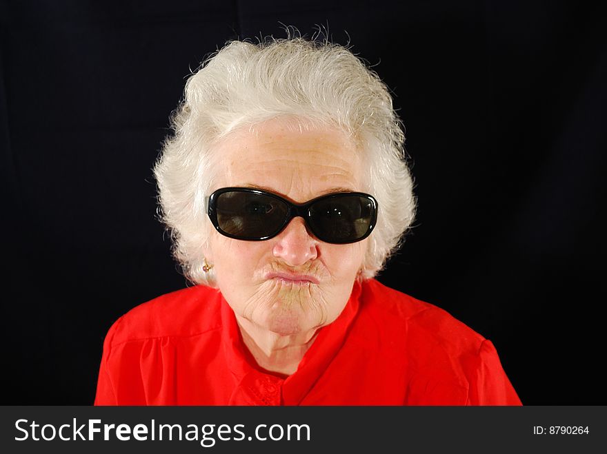 A portrait of elderly woman in red and in antisun glasses