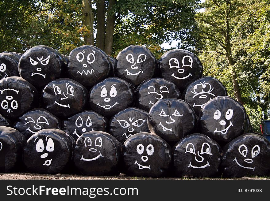 Cartoon faces showing emotions on black hay bags. Cartoon faces showing emotions on black hay bags