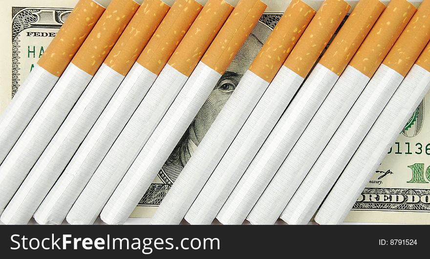 The cigarettes laying on american money