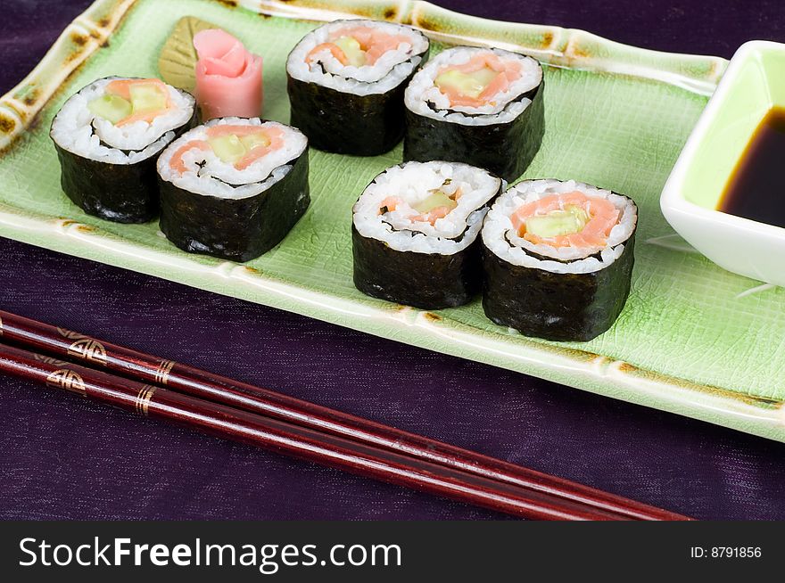A selection of rolls sushi against a magenta background