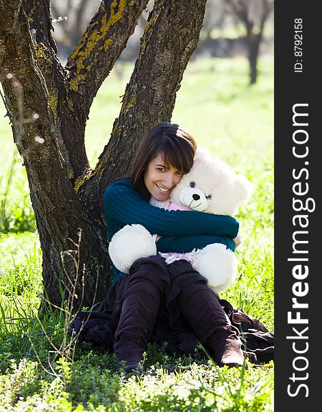 Young smiling woman embracing a teddy bear. Young smiling woman embracing a teddy bear