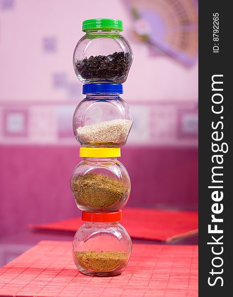 Four glass jars with spices and color covers