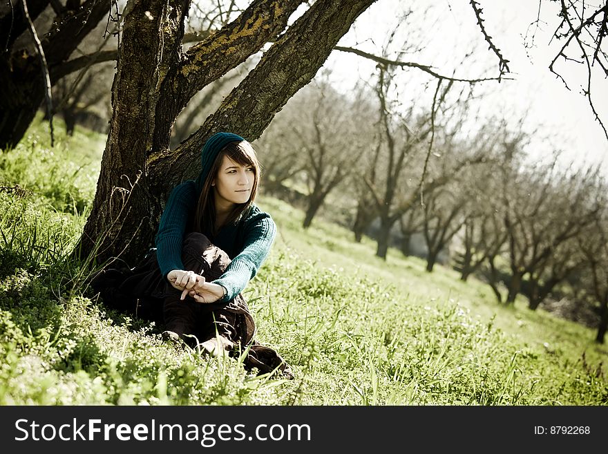 Young happy woman sitting in the forest. Young happy woman sitting in the forest.