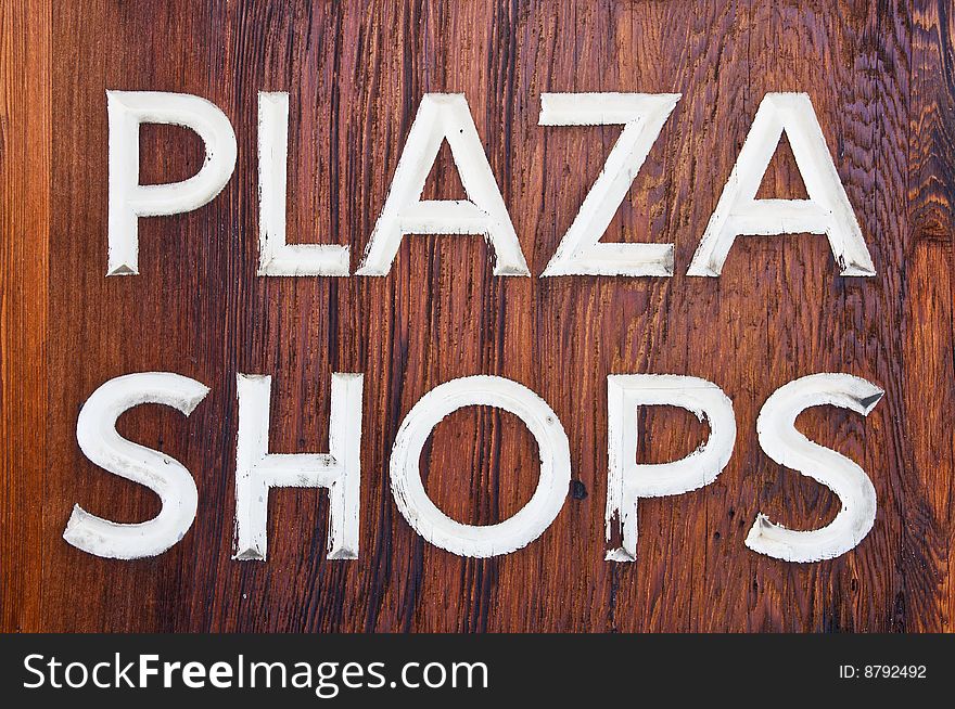 Old dark wooden Plaza Shops sign